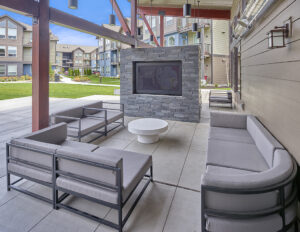 Outdoor fireplace area with multiple seating options and a coffee table at The Lodge Apartments at Marysville, WA.