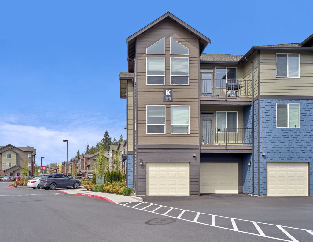 Exterior of building K at The Lodge Apartments with parking spaces at Marysville, WA.