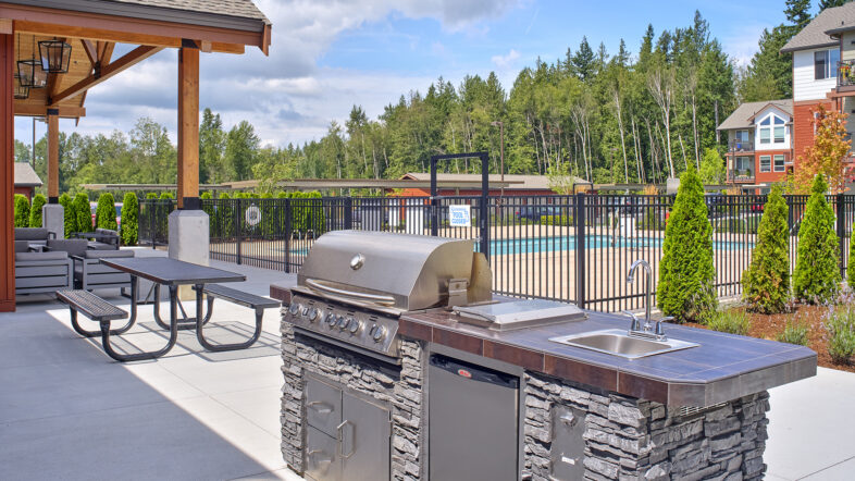 Grilling area in front of the fenced-in pool area at The Lodge Apartments at Marysville, WA.