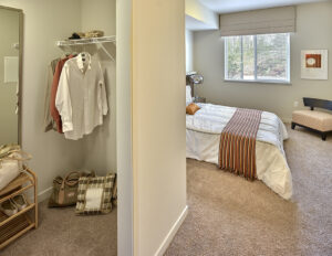 Carpeted bedroom with a walk-in closet in an apartment at The Lodge at Marysville, WA.