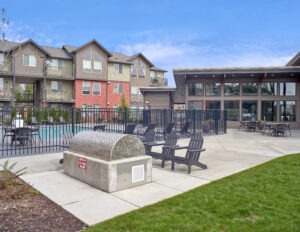 Fenced-in pool and outdoor fire pit area at The Lodge Apartments at Marysville, WA.