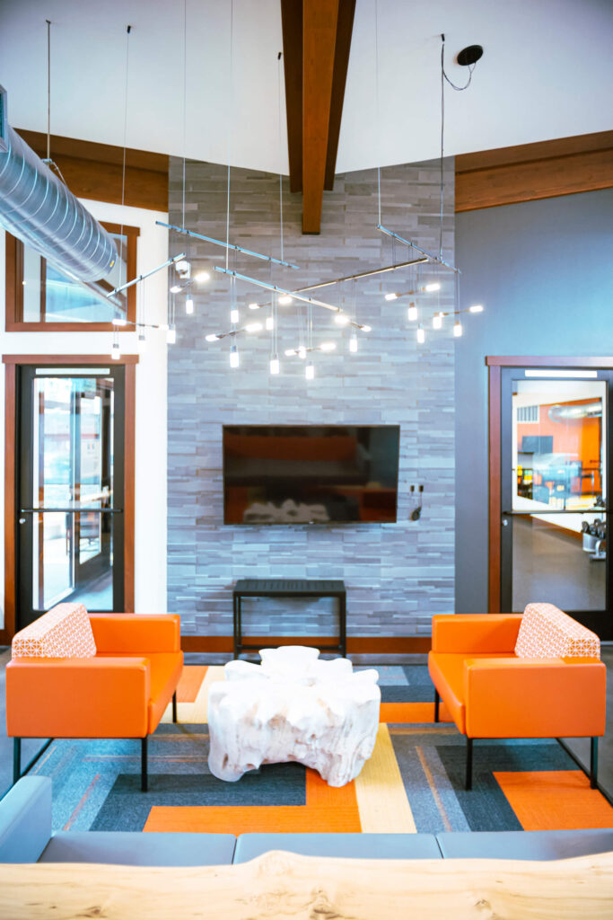 Clubhouse with TV and a variety of chairs at The Lodge Apartments at Marysville, WA.